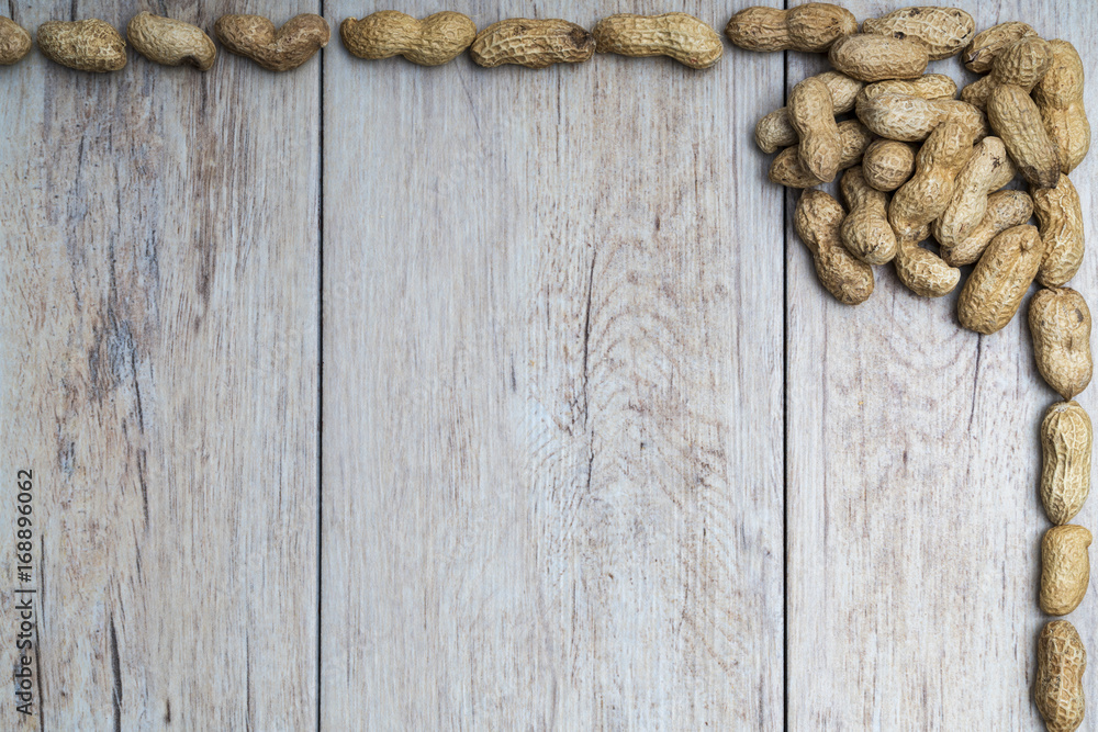 Fototapeta premium Peanuts on wood textured surface