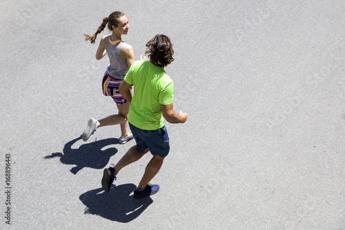 Handsome man and beautiful woman jogging together on street