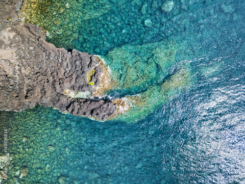 Aerial view of a lava formation in the crystal blue waters near the town of Canada de Africa in Sao Jorge, Portugal.