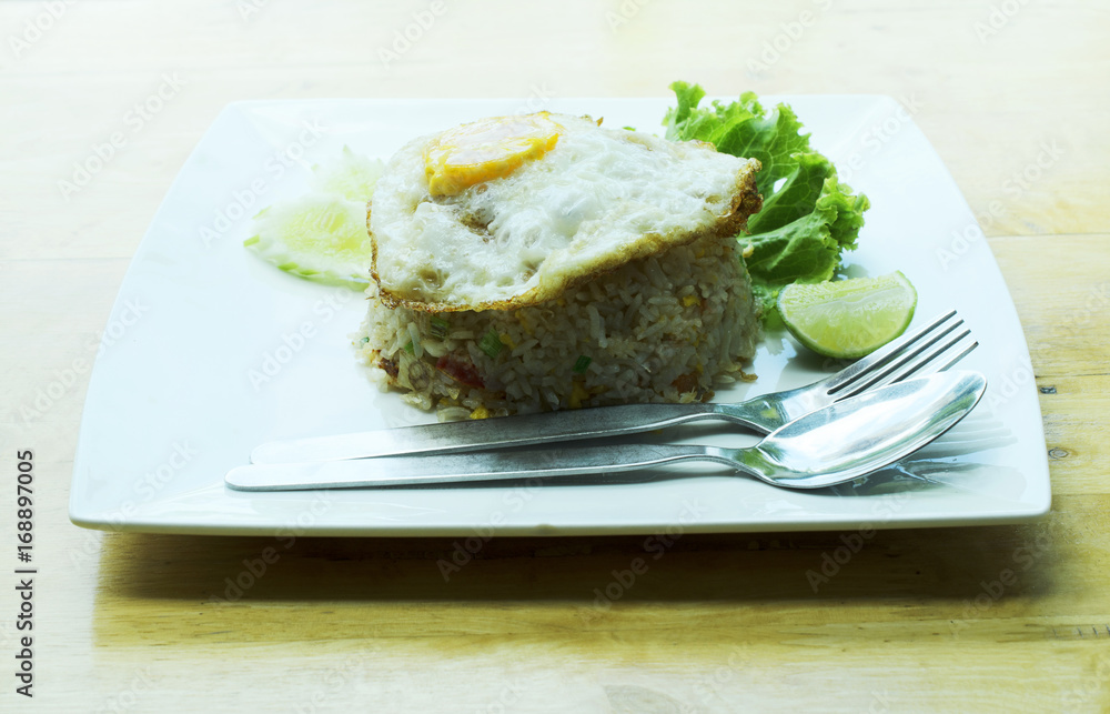 Crab Fried Rice with Fried Egg on white dish on wooden table backgrounds Crab Fried Rice with Fried Egg on white dish on wooden table backgrounds