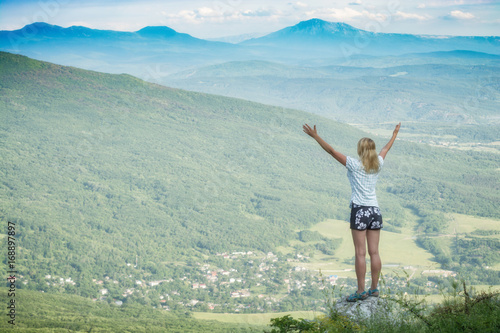 Happy woman standing on a cliffs edge