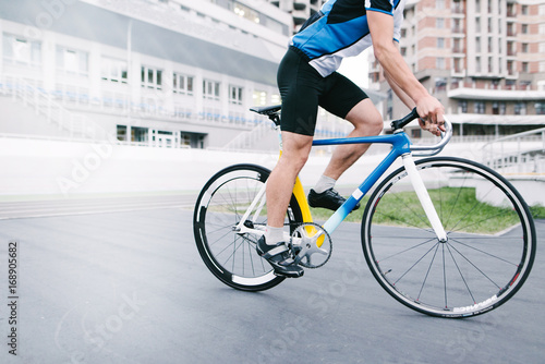 Athlete bicyclist rides against the backdrop of urban architecture. Man on a bright bike.