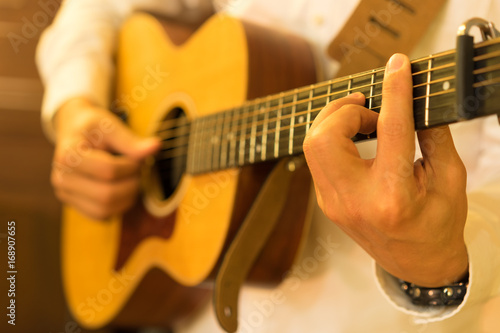 Man's hands playing acoustic guitar