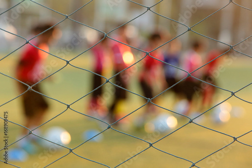 Blurred photo of youth training football in the football practice field. Sport concept.