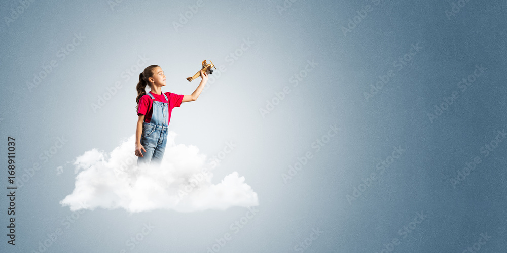 Concept of careless happy childhood with girl dreaming to become pilot