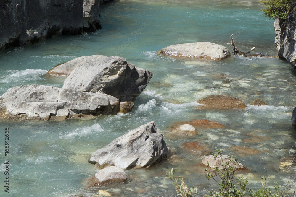 Detail of the glacial blue river water and rocks along the Tokumen River, Canada Detail of the glacial blue river water and rocks along the Tokumen River, Canada