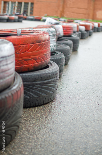 Fragment of a barrier on a carting track made of an old painted tires