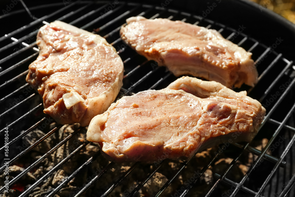 Raw steaks on grill outdoors Raw steaks on grill outdoors