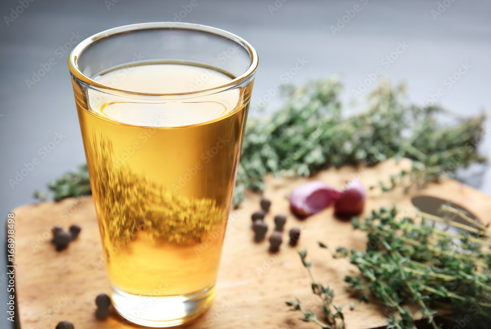 Glass with cooking oil on wooden board Glass with cooking oil on wooden board
