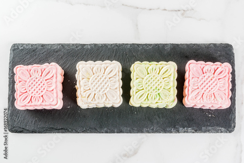 Asian, Japanian food,  Traditional sweet dessert multicolored no bake snow skin mooncakes on white marble table. copy space top view photo