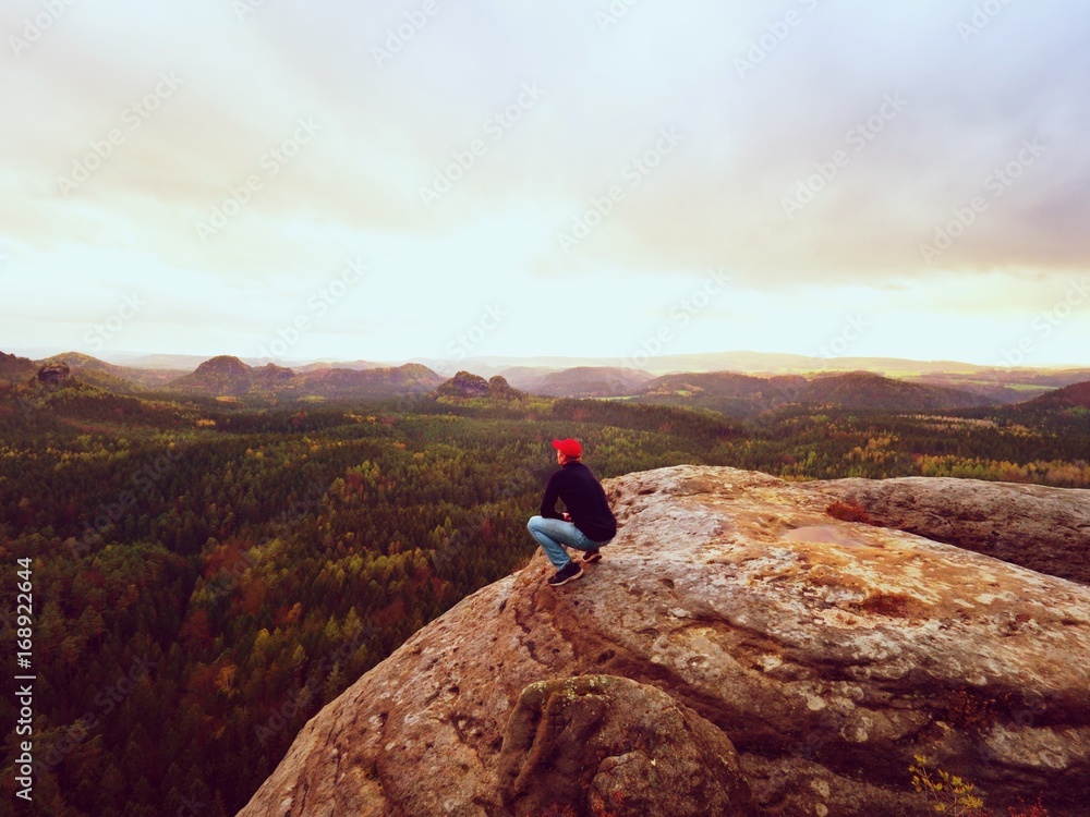 Man tourist sit on peak of mountain. Travel mountain scene. Hiker take a rest  alone on the mountain