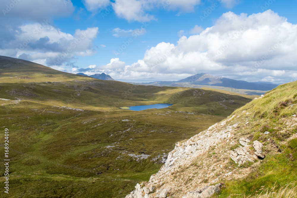 View of Lochan Fhionnlaidh and Canisp from hiking trail at Knockan Crag in North West Highlands Geopark, Scotland