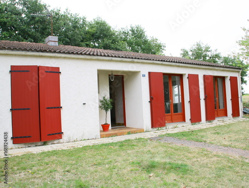 Photography maison traditionnelle aux volets battants rouges