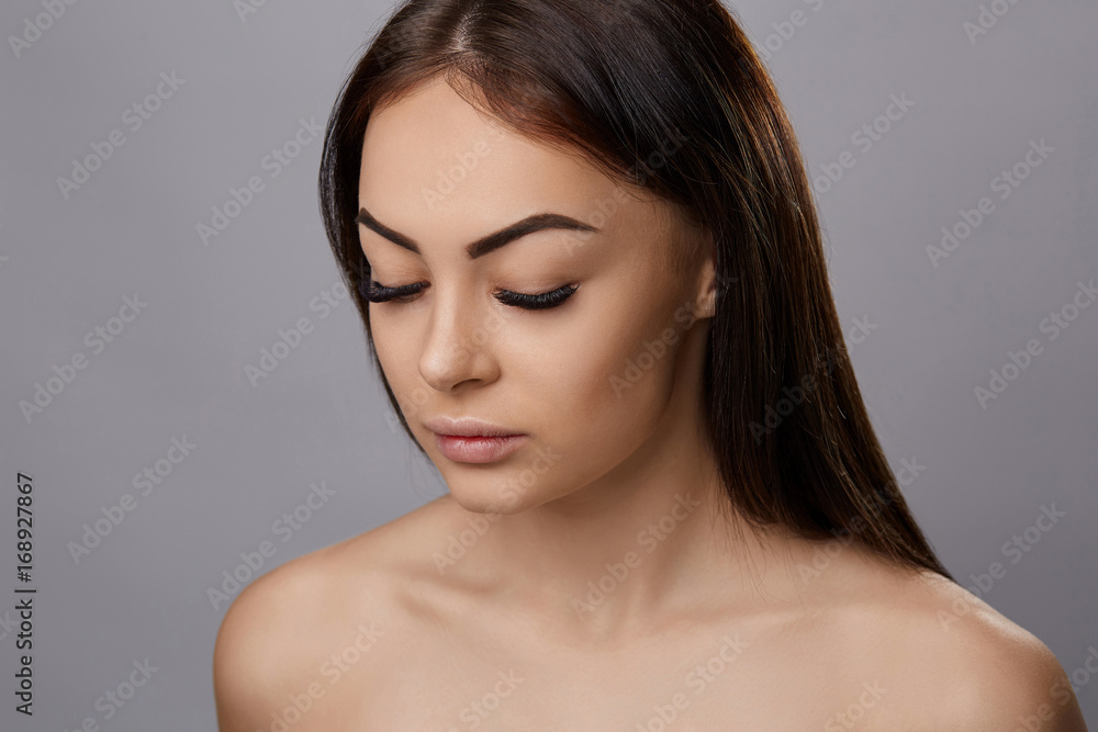 Eyelashes extensions. Fake Eyelashes. Closeup Of Beautiful Young Female Model With Soft Smooth Skin And Professional Facial Makeup. Portrait Of Sexy Girl With Long Fake Eyelashes And Perfect Make-up. Eyelashes extensions. Fake Eyelashes. Closeup Of Beautiful Young Female Model With Soft Smooth Skin And Professional Facial Makeup. Portrait Of Sexy Girl With Long Fake Eyelashes And Perfect Make-up.