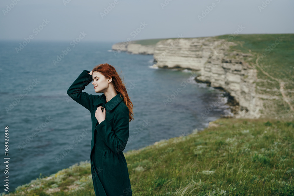 A woman on a cliff near the sea