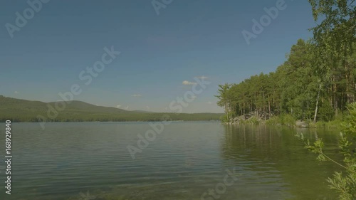 Beautiful mountain lake in the forest. Beautiful landscape with a lake. In the mirror surface of the water reflects the blue sky photo