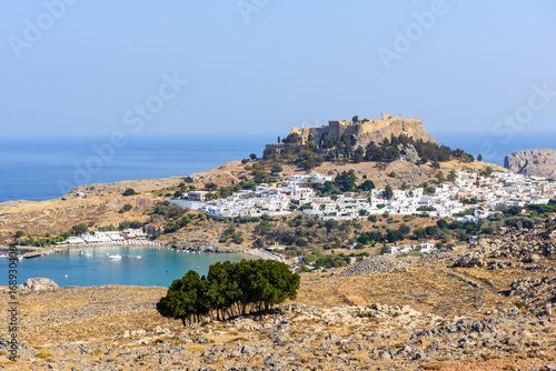 Panoramic view on Lindos town with a beautiful lagoon and ancient fortress on a hill at Rhodes island, Greece