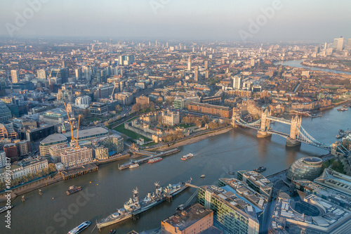 a view of Thames river and London at sunset with red sky and air pollution with Tower bridge
