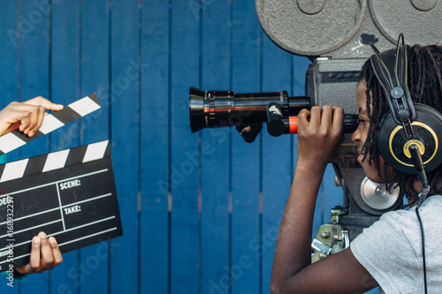 Black girl filming with an old 16mm film camera