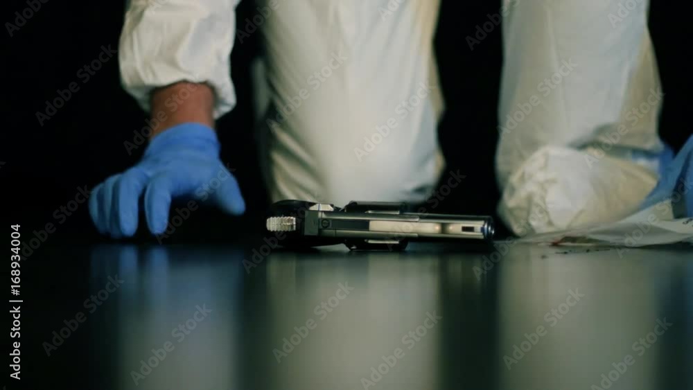 Weapon Evidence Crime scene forensic detective, revolver placed into plastic evidence ...