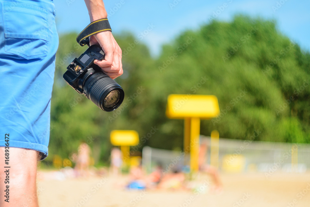 DSLR camera in hand in sea beach background Stock Photo | Adobe Stock