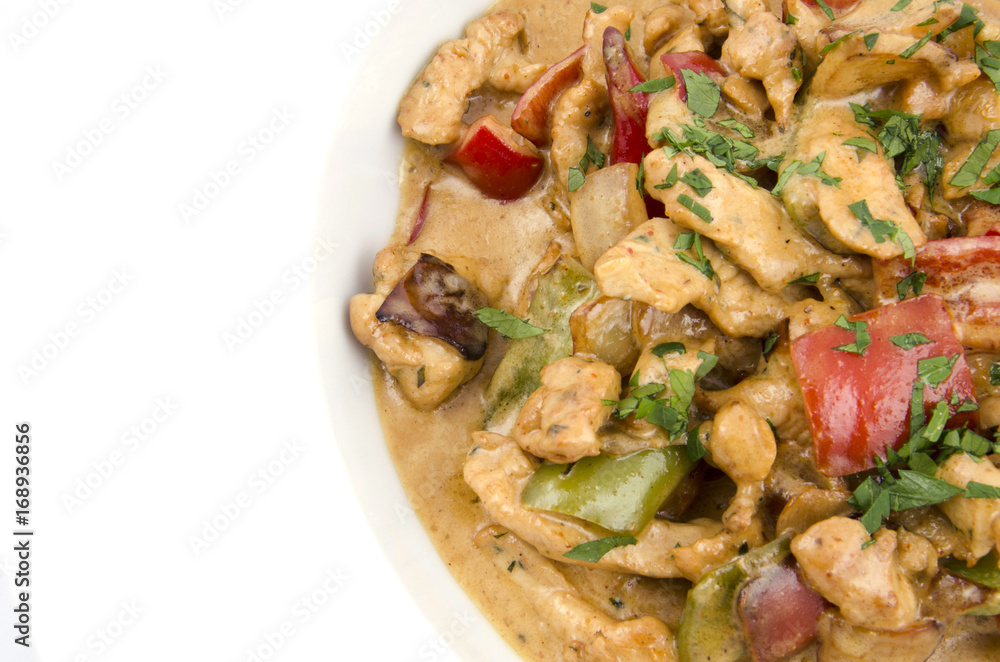 curry sauce on the plate of chicken with vegetables on a white background curry sauce on the plate of chicken with vegetables on a white background