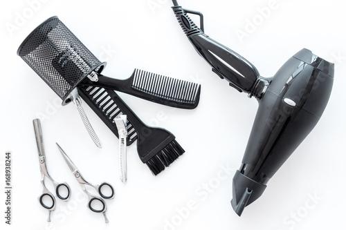 hairdresser working desk with tools for hair styling on white desk background top view