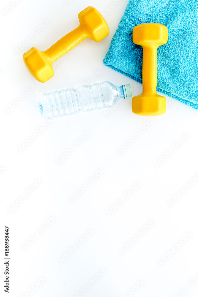 Fitness background. Dumbbells, towel and water on white background top view copyspace Fitness background. Dumbbells, towel and water on white background top view copyspace