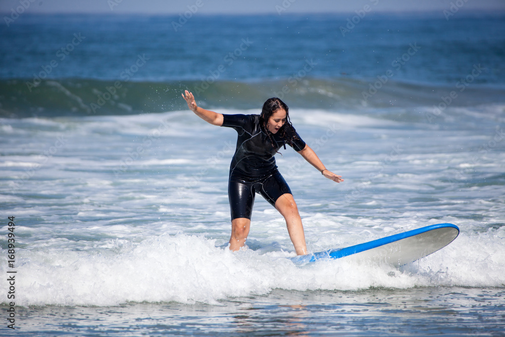 young woman on her surfboard