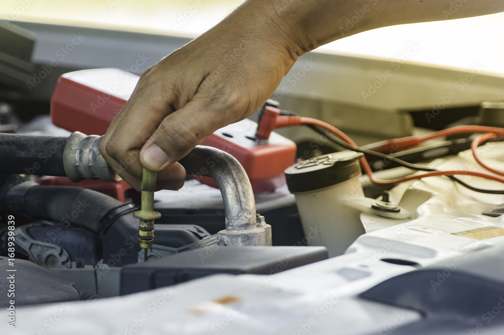 Auto mechanic uses hand of technician checking or fixing engine of in a car. Auto mechanic uses hand of technician checking or fixing engine of in a car.