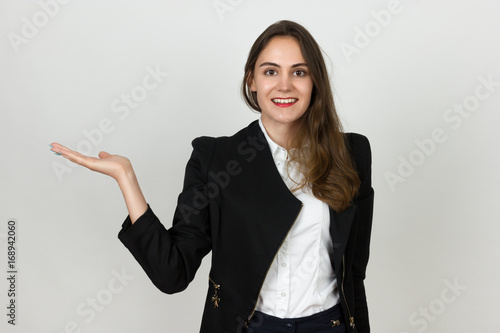 Portrait of a pretty young businesswoman presenting with one hand