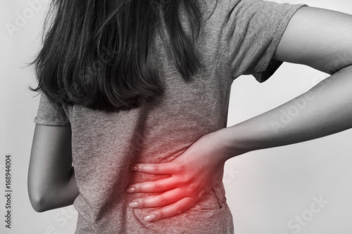  Pretty woman suffers from backache. Black and white with red accent. Pain concept close-up