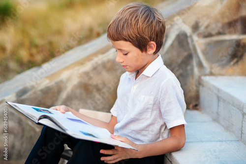 Child doing his homework outdoors after school.