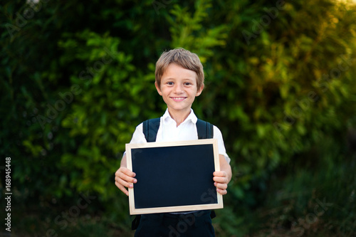School kid holding a blackboard with back to school message