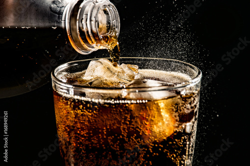 poured beverrage into a glass with ice,Cola drink is fizzy photo