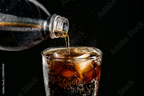 poured beverrage into a glass with ice,Cola drink is fizzy
