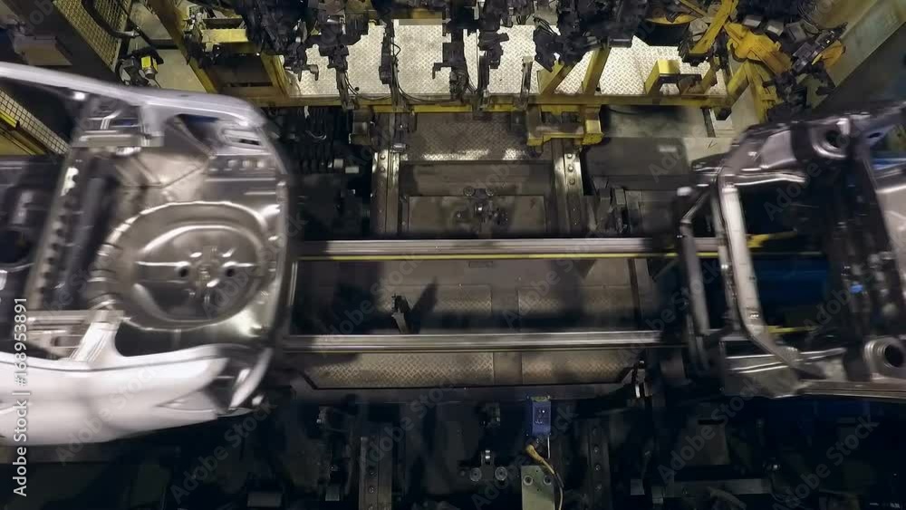 aluminium car bodies are moving over conveyor line, automatically ...