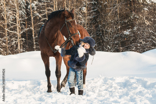 Small girl and horse in a winter © keleny
