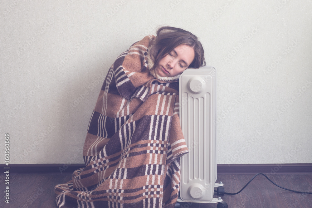 young woman in woolen plaid warm up hands over electric heater - obrazy, fototapety, plakaty 