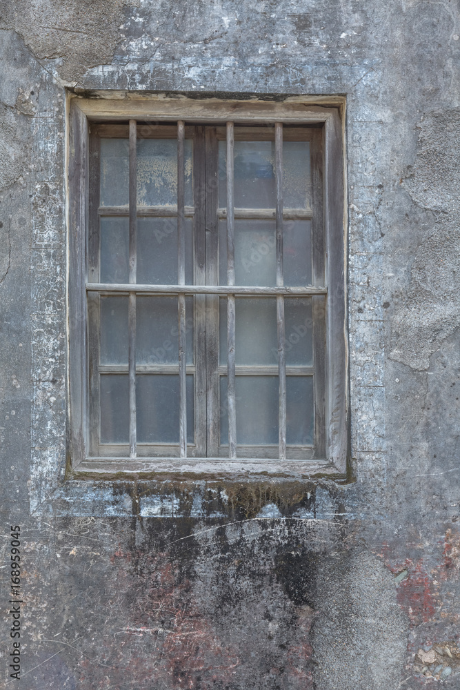 exterior view of old wall with closed glass window.