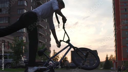 BMX freestyle on the city street. BMX flatland tricks. Hipster on the BMX bike.
