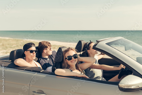 Smiling friends driving car near the sea and having fun © fotofabrika
