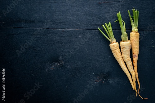 Parsley. Root parsley. On a wooden background. Top view. Free space for text.