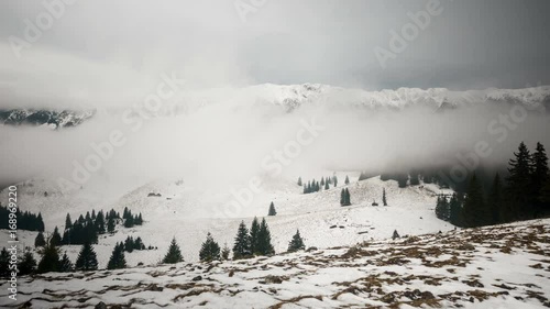 Wallpaper Mural Piatra Craiului panorama in winter. 	Grey clouds rolling over Piatra Craiului Mountains in background and isolated trees in foreground. 4k timelapse.  Torontodigital.ca