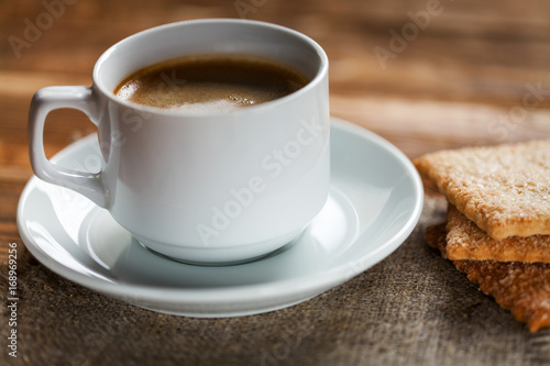 Coffee cup and cookie on wood