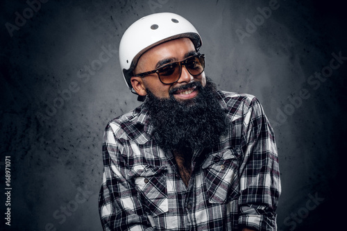 Smiling bearded hipster male dressed in a fleece shirt and sunglasses.