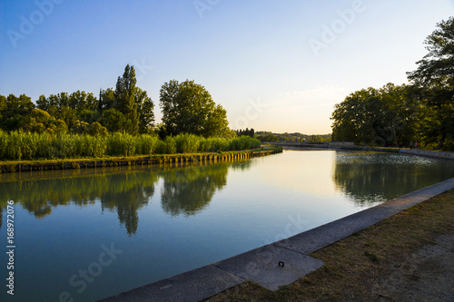 The Canal du Midi in Beziers at sunset, a long canal that connects the Atlantic Ocean with the Mediterranean Sea in Southern France. A world heritage site since 1996
