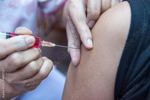 soft focus nurses are vaccinations to patients using the syringe.Doctor vaccinating women in hospital.Are treated by the use of sterile injectable upper arm.
