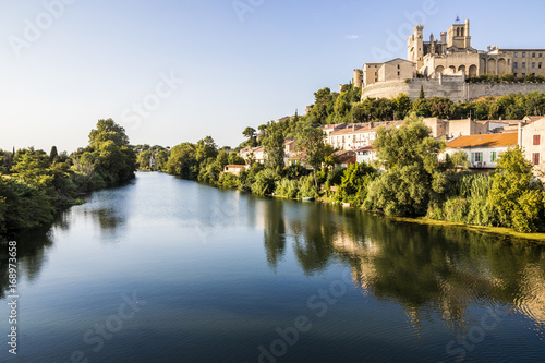 Views at sunset of the French city of Beziers  with trees  the river Orb  and the 13th-century Cathedral of Saint Nazaire in the background