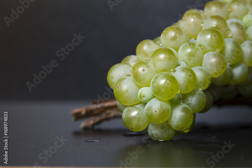 Grappolo d'uva Grechetto Gentile su corteccia di legno (dettaglio) photo